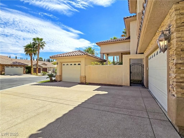 5445 Pendini Point Ct, Las Vegas, NV 89141 - view of side of property with stucco siding, a tile roof, a gate, and a garage