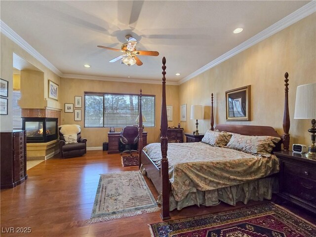 5445 Pendini Point Ct, Las Vegas, NV 89141 - bedroom with wood finished floors, a multi sided fireplace, crown molding, recessed lighting, and baseboards