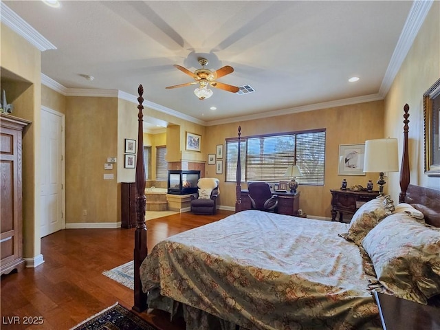 5445 Pendini Point Ct, Las Vegas, NV 89141 - bedroom featuring a multi sided fireplace, wood finished floors, baseboards, recessed lighting, and crown molding