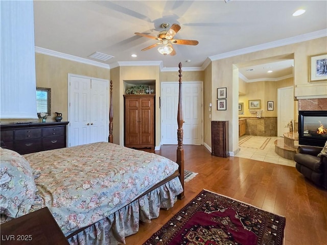 5445 Pendini Point Ct, Las Vegas, NV 89141 - bedroom with wood finished floors, recessed lighting, a fireplace, baseboards, and ornamental molding