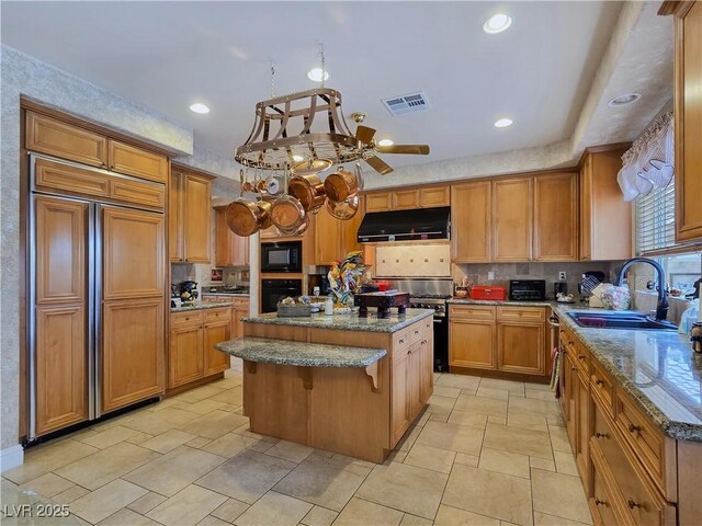5445 Pendini Point Ct, Las Vegas, NV 89141 - kitchen featuring black appliances, under cabinet range hood, a sink, a kitchen island, and dark stone countertops