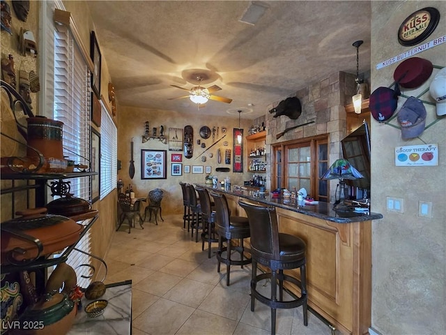 5445 Pendini Point Ct, Las Vegas, NV 89141 - indoor bar with a ceiling fan, light tile patterned floors, and pendant lighting