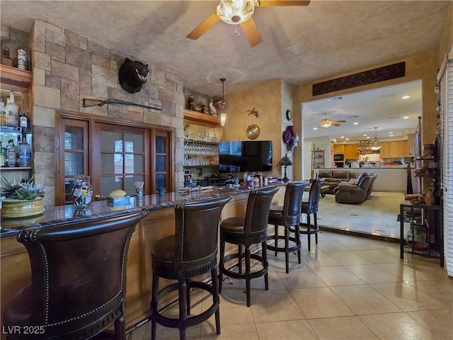 5445 Pendini Point Ct, Las Vegas, NV 89141 - indoor bar featuring a ceiling fan, light tile patterned flooring, and hanging light fixtures