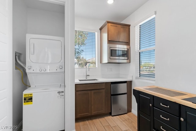 3709 Neblina Dr, Henderson, NV 89052 - laundry room featuring stacked washer / drying machine, light wood-style flooring, and baseboards
