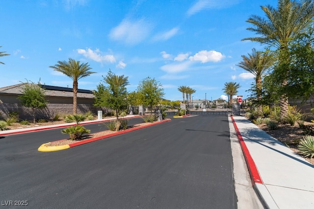 3709 Neblina Dr, Henderson, NV 89052 - view of asphalt street with sidewalks, curbs, a gate, a gated entry, and traffic signs