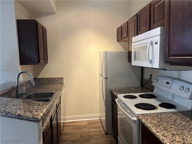 5170 S Jones Blvd Unit 108, Las Vegas, NV 89118 - kitchen with white appliances, a sink, baseboards, dark brown cabinetry, and dark wood-style floors