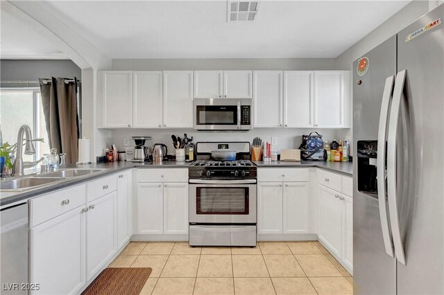 9065 Adorable Ave, Las Vegas, NV 89149 - kitchen featuring appliances with stainless steel finishes, a sink, white cabinets, and light tile patterned flooring