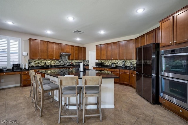 7520 Fontera Ct, Las Vegas, NV 89139 - kitchen featuring freestanding refrigerator, double oven, under cabinet range hood, dark countertops, and recessed lighting