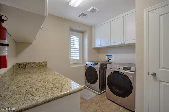 7520 Fontera Ct, Las Vegas, NV 89139 - laundry area featuring independent washer and dryer, cabinet space, and light tile patterned floors