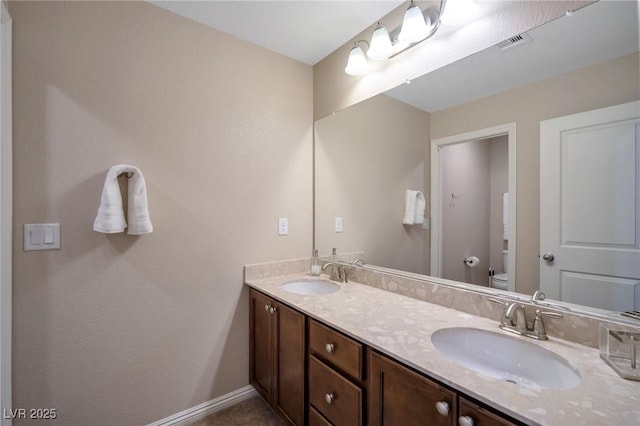 7520 Fontera Ct, Las Vegas, NV 89139 - bathroom with toilet, double vanity, and baseboards