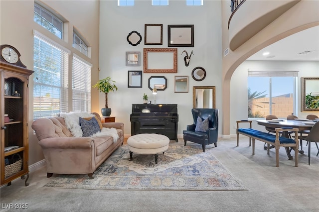 7778 Villa Montara St, Las Vegas, NV 89123 - carpeted living area featuring arched walkways, a high ceiling, healthy amount of natural light, and baseboards