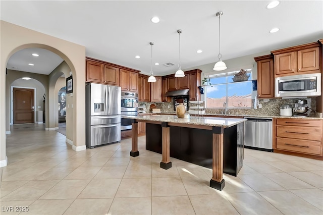 7778 Villa Montara St, Las Vegas, NV 89123 - kitchen with stainless steel appliances, under cabinet range hood, tasteful backsplash, a kitchen island, and a kitchen bar