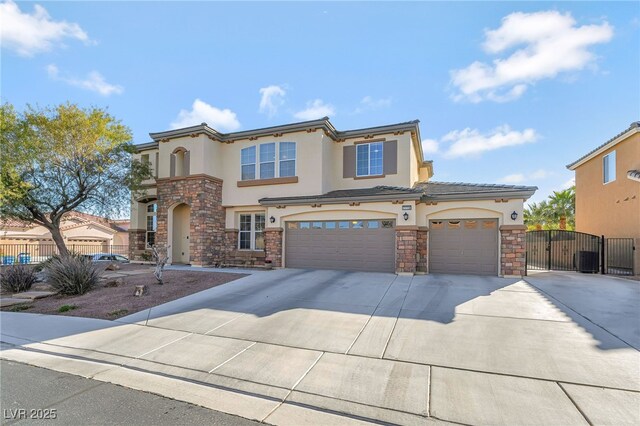 7778 Villa Montara St, Las Vegas, NV 89123 - mediterranean / spanish house featuring stone siding, stucco siding, driveway, and a gate
