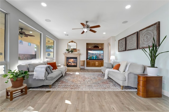 7778 Villa Montara St, Las Vegas, NV 89123 - living area featuring a ceiling fan, wood finished floors, a glass covered fireplace, recessed lighting, and arched walkways