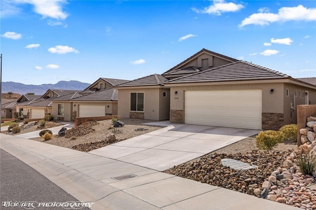 942 Shadow Hawk Rdg, Mesquite, NV 89027 - ranch-style house with stone siding, stucco siding, a mountain view, and a garage