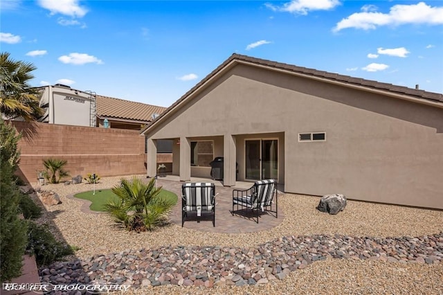 942 Shadow Hawk Rdg, Mesquite, NV 89027 - back of property featuring an area to practice putting, fence, a patio, and stucco siding
