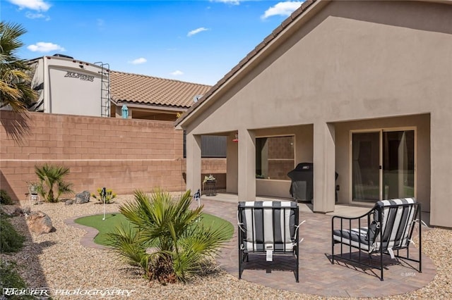 942 Shadow Hawk Rdg, Mesquite, NV 89027 - rear view of house featuring an area to practice putting, stucco siding, a patio area, and fence