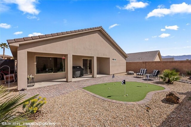 942 Shadow Hawk Rdg, Mesquite, NV 89027 - back of property featuring a putting area, a patio, stucco siding, and fence