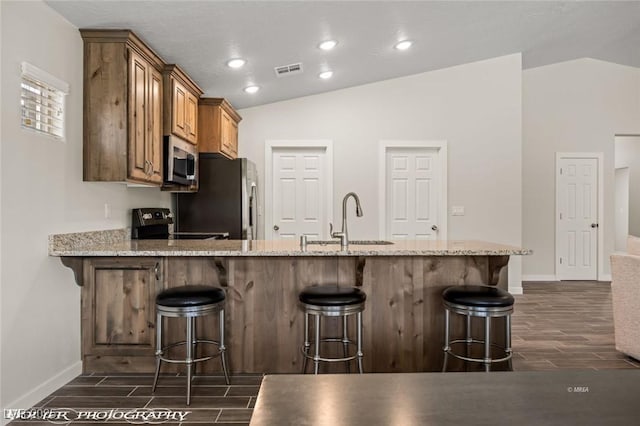 942 Shadow Hawk Rdg, Mesquite, NV 89027 - kitchen with stainless steel appliances, a sink, vaulted ceiling, wood tiled floors, and baseboards