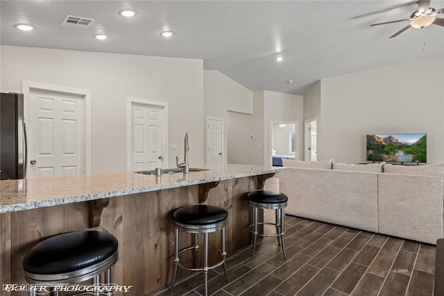 942 Shadow Hawk Rdg, Mesquite, NV 89027 - kitchen featuring a sink, freestanding refrigerator, vaulted ceiling, ceiling fan, and dark wood-style floors