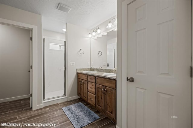 942 Shadow Hawk Rdg, Mesquite, NV 89027 - bathroom with baseboards, wood tiled floors, double vanity, and a textured ceiling