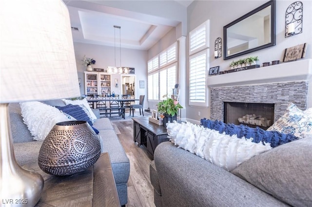 53 Grossinger Ct, Henderson, NV 89074 - living room with wood finished floors, a raised ceiling, a fireplace, and a chandelier