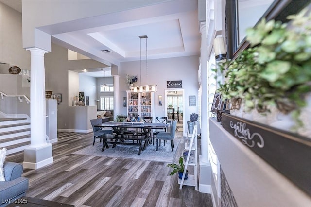 53 Grossinger Ct, Henderson, NV 89074 - dining room with a tray ceiling, dark wood-type flooring, baseboards, stairs, and decorative columns