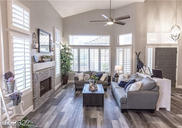 53 Grossinger Ct, Henderson, NV 89074 - living room with a fireplace, baseboards, ceiling fan, dark wood finished floors, and high vaulted ceiling