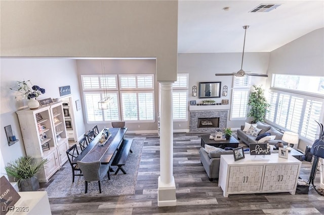 53 Grossinger Ct, Henderson, NV 89074 - living room with dark wood-style flooring, a ceiling fan, a fireplace, lofted ceiling, and ornate columns