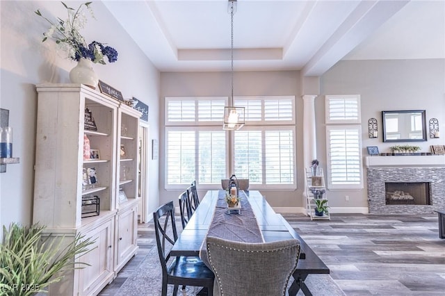 53 Grossinger Ct, Henderson, NV 89074 - dining area featuring a tray ceiling, wood finished floors, a stone fireplace, and baseboards