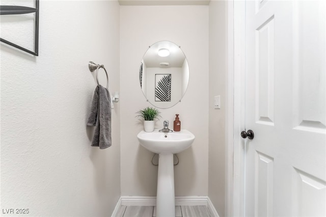 bathroom featuring baseboards and a sink