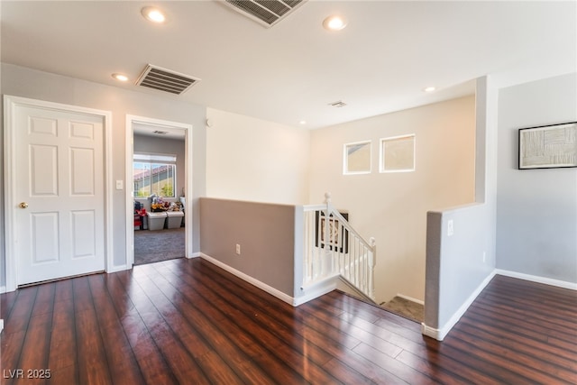 empty room with wood finished floors, baseboards, and recessed lighting