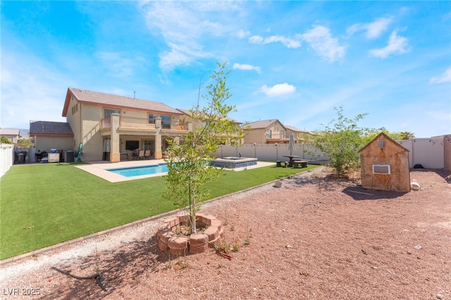 rear view of house featuring a balcony, stucco siding, a patio, and a pool with connected hot tub