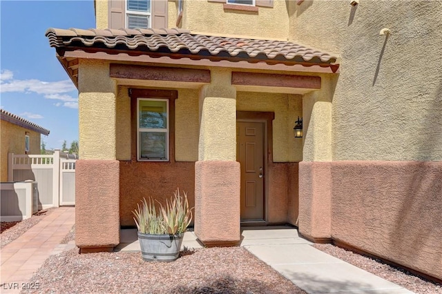 952 Crescent Falls St, Henderson, NV 89011 - doorway to property featuring stucco siding, fence, and a tiled roof