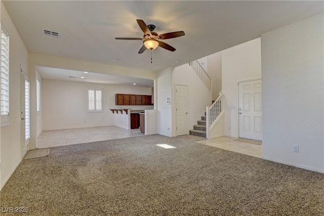 952 Crescent Falls St, Henderson, NV 89011 - unfurnished living room featuring light carpet, a ceiling fan, stairway, light tile patterned flooring, and baseboards
