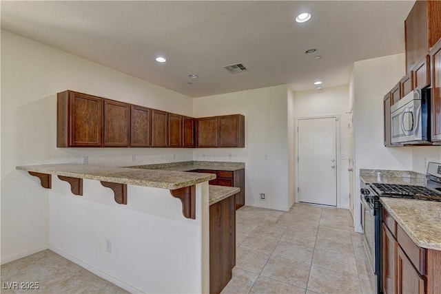 952 Crescent Falls St, Henderson, NV 89011 - kitchen featuring stainless steel appliances, a peninsula, a breakfast bar area, recessed lighting, and light stone counters