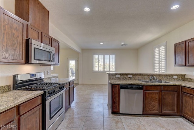 952 Crescent Falls St, Henderson, NV 89011 - kitchen with appliances with stainless steel finishes, a sink, a peninsula, light stone countertops, and recessed lighting