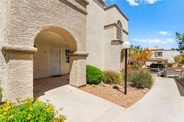 doorway to property featuring stucco siding