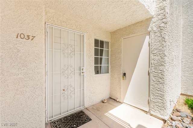 entrance to property with stucco siding