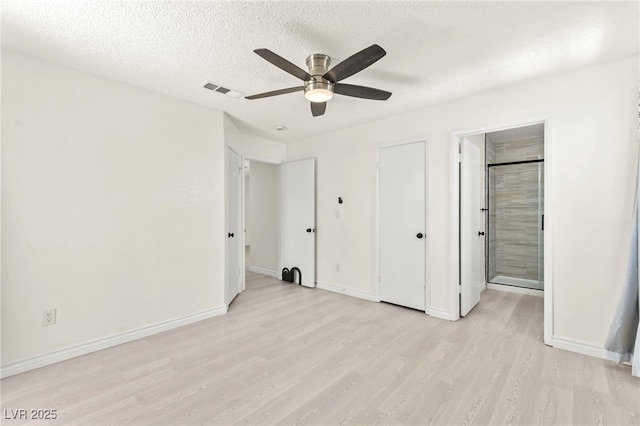 unfurnished bedroom with light wood-style floors, a textured ceiling, baseboards, and a ceiling fan
