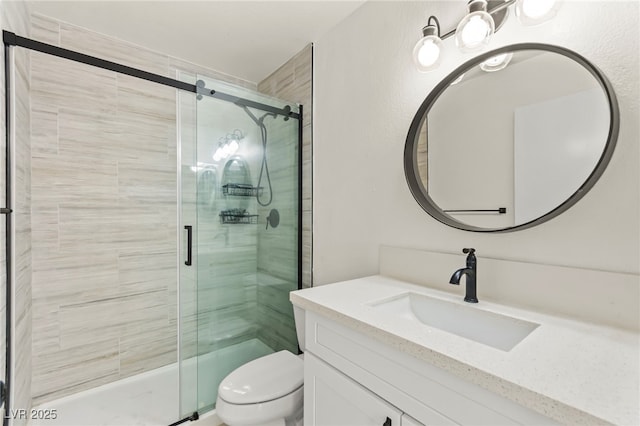 bathroom featuring a stall shower, toilet, and vanity
