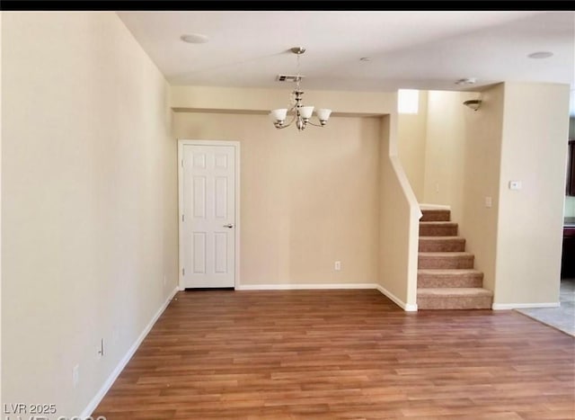 7563 Captain Lord Ct, Las Vegas, NV 89166 - empty room featuring light wood-style floors, a chandelier, stairs, and baseboards