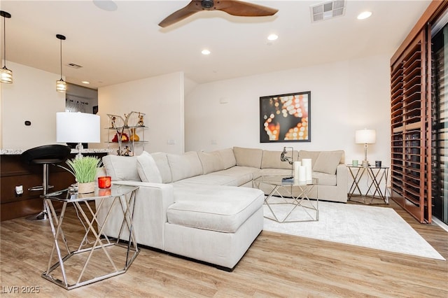 living area with wood finished floors, ceiling fan, and recessed lighting
