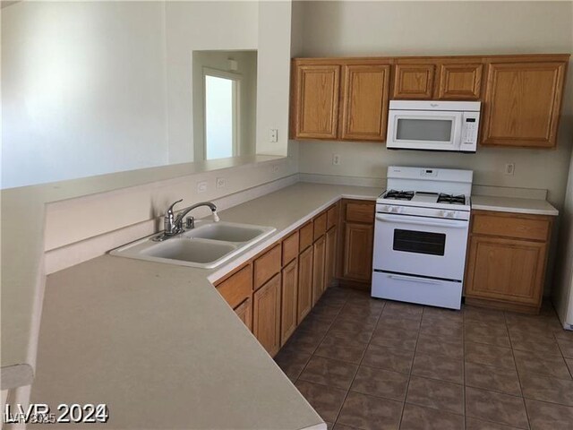 1083 Sterling Peak St, Las Vegas, NV 89110 - kitchen featuring white appliances, a sink, light countertops, and brown cabinetry