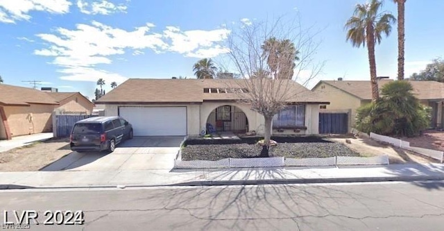 single story home featuring a garage, stucco siding, driveway, and fence