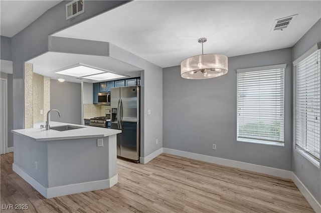 1501 Oscar Ct Unit 101, Las Vegas, NV 89146 - kitchen featuring a sink, stainless steel appliances, light wood-style floors, and healthy amount of natural light