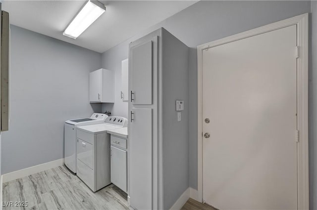 1501 Oscar Ct Unit 101, Las Vegas, NV 89146 - laundry area with cabinet space, washer and clothes dryer, baseboards, and light wood-type flooring