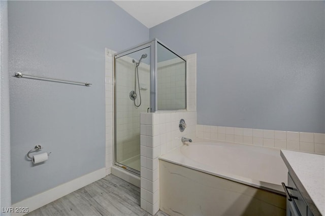 1501 Oscar Ct Unit 101, Las Vegas, NV 89146 - bathroom featuring wood finished floors, a stall shower, a garden tub, baseboards, and vanity