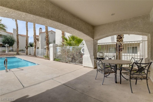1501 Oscar Ct Unit 101, Las Vegas, NV 89146 - view of patio with fence, a community pool, and outdoor dining area