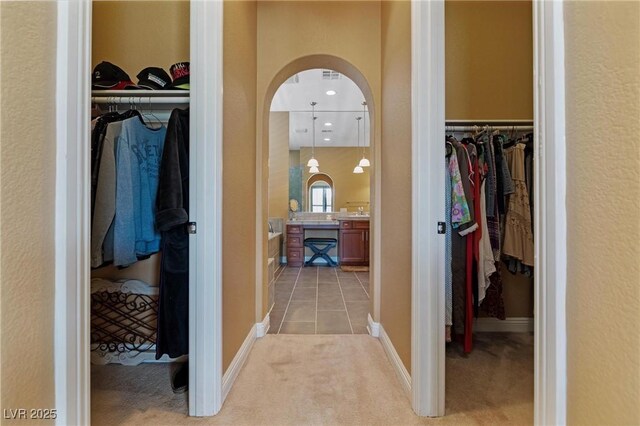 7719 Villa Montara St, Las Vegas, NV 89123 - hallway with arched walkways, light carpet, light tile patterned floors, and baseboards